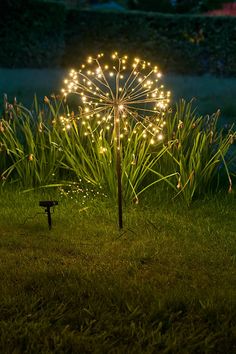 a lit up umbrella sitting in the grass