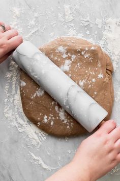 a person rolling out dough on top of a table