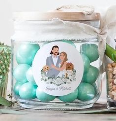 a glass jar filled with green and white candies next to a potted plant