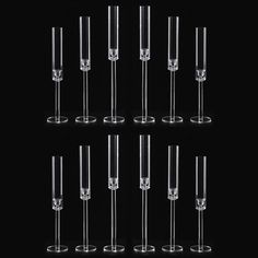 six wine goblets are lined up against a black background, each filled with liquid