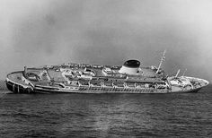 an old photo of a large ship in the middle of the ocean on a cloudy day