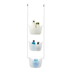 three hanging baskets with soap, toothpaste and lotion in them against a white background