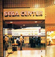 people are walking in and out of the sega center store front door at night