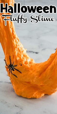 an orange slime with a spider on it and the words halloween fluffy slime