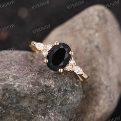 a black diamond ring sitting on top of a rock