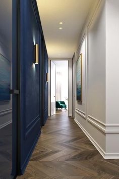 an empty hallway with wood floors and blue doors