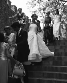 black and white photograph of bride walking down stairs with her groom on the other side