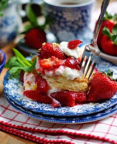 strawberries and whipped cream are on top of this dessert with a fork in it