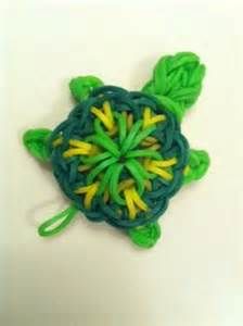 a close up of a green and yellow turtle brooch on a white surface,