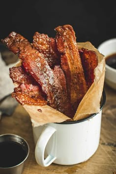 some bacon sticks in a white cup on a table