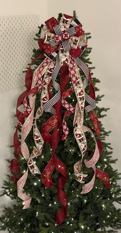 a decorated christmas tree with red and white ribbons