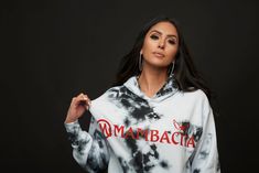 a woman wearing a black and white tie dye hoodie with the words mamabacia on it