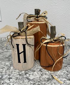 three wooden barrels with the letter h painted on them