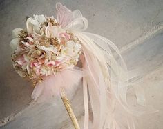 a bridal bouquet with pink and white flowers on it sitting on a ledge next to a wall