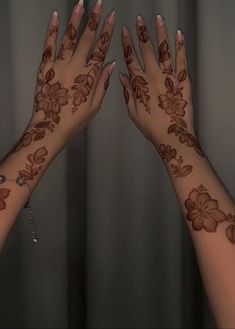 two hands with henna tattoos on their palms