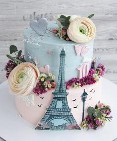 a cake decorated with flowers and the eiffel tower