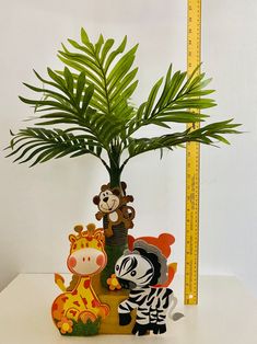 there is a plant that has been placed on the table with animals and zebras