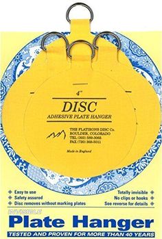 a yellow plate hanger with blue and white designs on the front, in a package