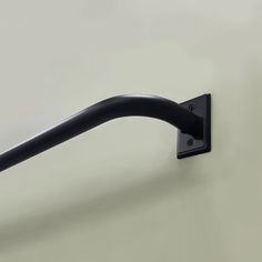 a black handle on the side of a white wall