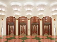 an empty room with three elevators and several lamps