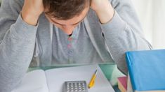 a person sitting at a desk with a calculator and notebook in front of them