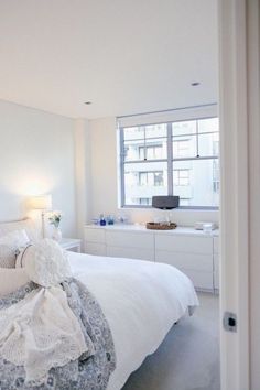 a bedroom with a bed, dressers and window in it's center area