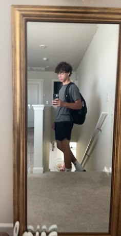 a young man taking a selfie in front of a mirror