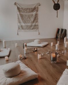 a room with candles and pillows on the floor