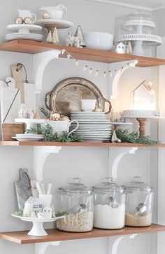 the shelves are filled with dishes and other kitchen items in glass jars on top of wooden shelves