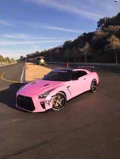 a pink sports car is parked on the road