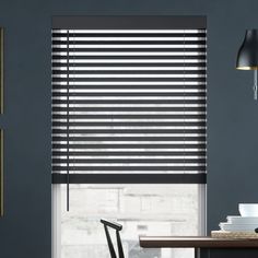 the blinds in this kitchen are made out of black and white striped fabric, with dark wood accents