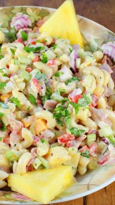 a bowl filled with macaroni salad on top of a wooden table