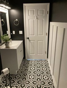 a bathroom with black and white tile on the floor