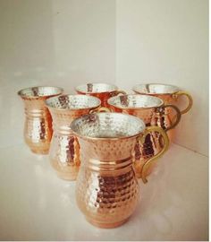 a set of six copper pitchers with handles