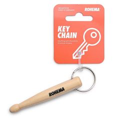 a key chain with a wooden handle is in front of an orange card and white tag