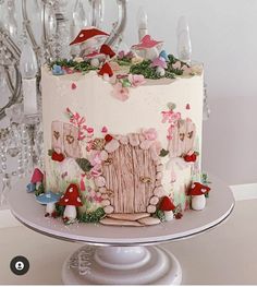 there is a cake decorated with flowers and mushrooms on the table next to a chandelier