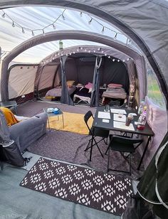 the inside of a tent with furniture and lights