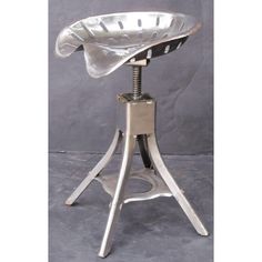 an old fashioned metal stool with a hat on it