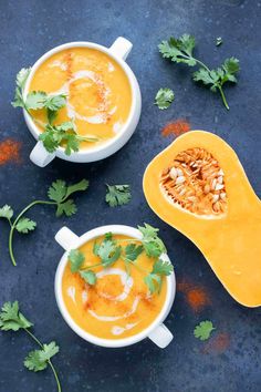 two white bowls filled with soup and garnished with parsley