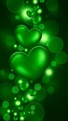 two green hearts on a black background with bubbles in the shape of heart shaped shapes