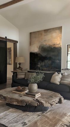 a living room filled with furniture and a painting on the wall