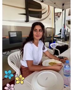 a woman sitting at a table with plates in front of her