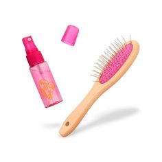 the brush is next to an empty bottle with pink liquid on it and another item in the background