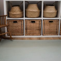 wicker baskets and rocking chair in front of bookshelf with white bookcase