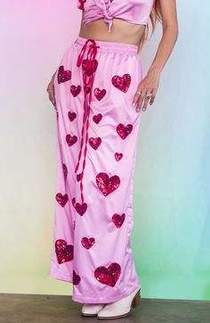 Introducing our Cupid's Crossfire Satin lounge pants- our venture into comfy everyday clothes that bring some sparkle into your world! These wide leg silky pants are hand beaded with delicate red hearts and have a comfy elastic waistband with a red satin tie. The inseam is roughly 28". Perfect for any occasion - whether you're at a festival, on a night out with your friends or just at home looking fabulous. In stock and ready to ship- Limited Stock! Flaming Dragon, Silky Pants, Headpiece Accessories, Everyday Clothes, Red Hearts, Red Satin, Limited Stock, Lounge Pants, Hand Beading