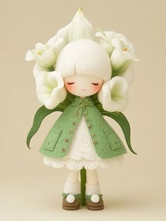 a little doll with flowers in her hair and green coat on it's head