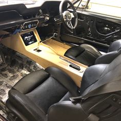 the interior of a car with black leather seats and steering wheel, including an electronic display