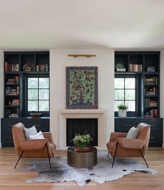 a living room with two chairs and a fire place