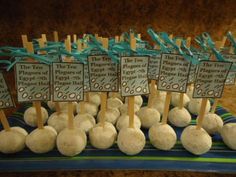 a table topped with lots of white donuts covered in frosting and blue ribbon