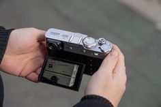 a person holding up a camera to take a picture with the lens pointed at it